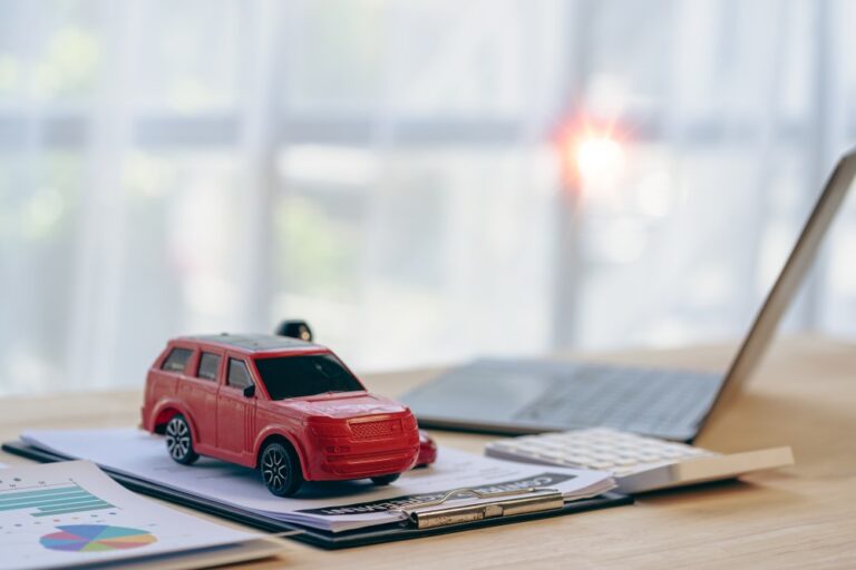 Toy car on insurance documents showing insurance gaps after a Richmond car accident