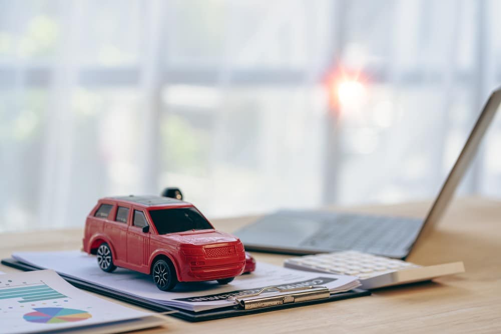 Toy car on insurance documents showing insurance gaps after a Richmond car accident