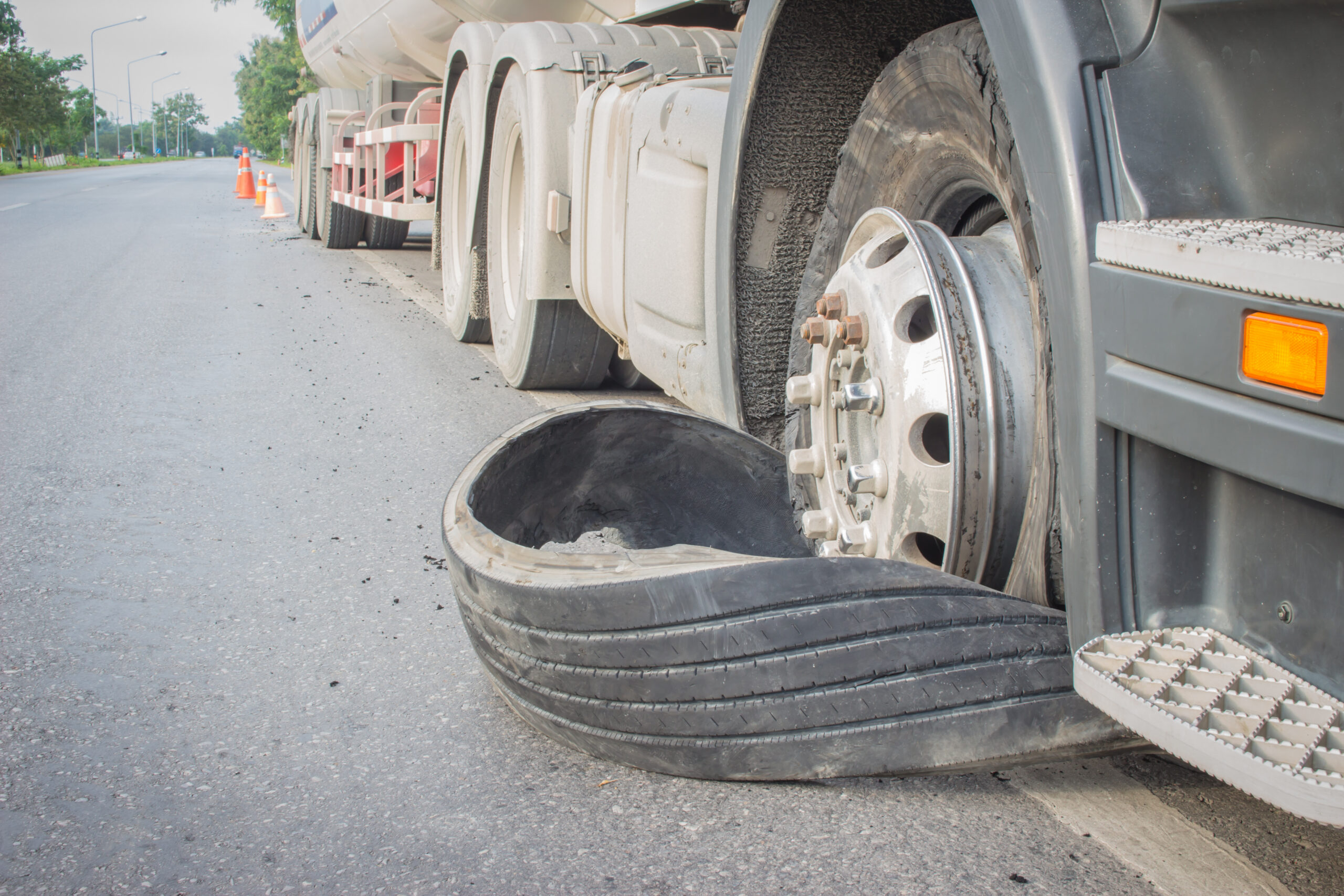 Tractor-trailer tire blowout on Richmond highway shoulder showing detached commercial truck tire and damaged wheel